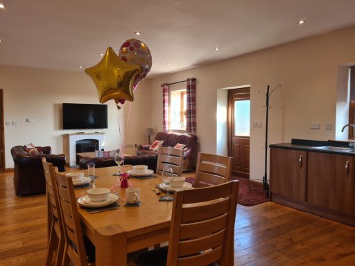 Spacious living area with a dining table, balloons, and modern furnishings.